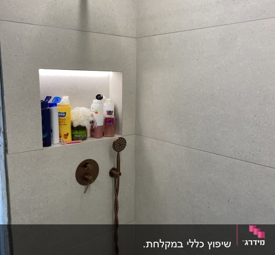 מקלחת עם ראש מקלחת ומוצרים על מדף